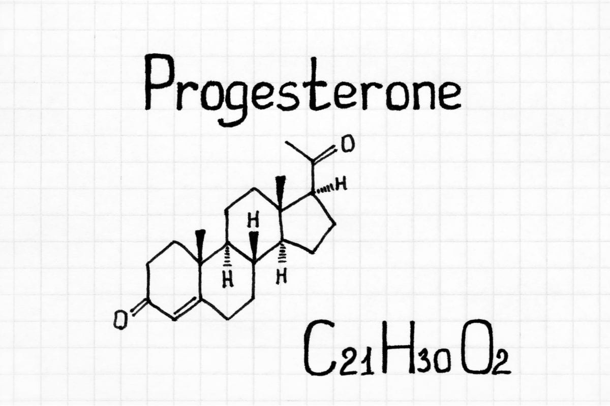 A white gridded background with black handwriting that says Progesterone and gives the chemical molecular symbol picture drawn underneath the word.