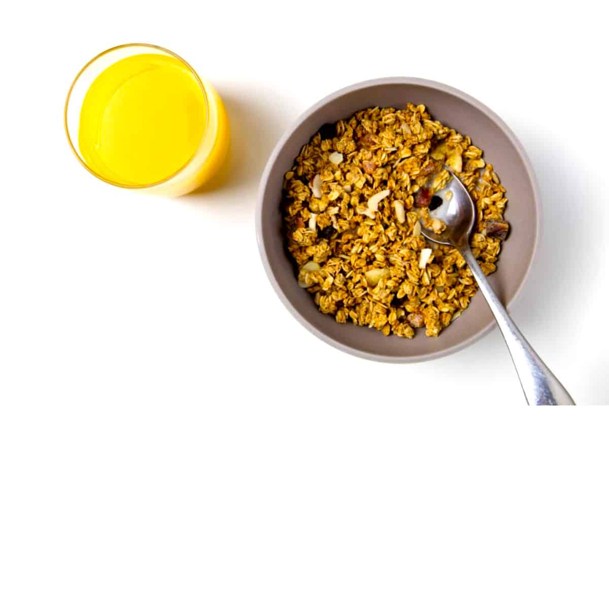 a bowl of granola cereal with orange juice representing prebiotic fiber for the benefit of gut health