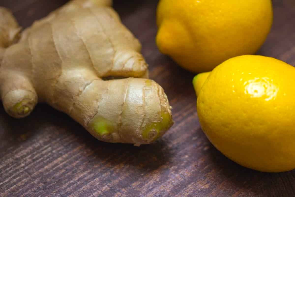 a photo of ginger root raw, next to two lemons