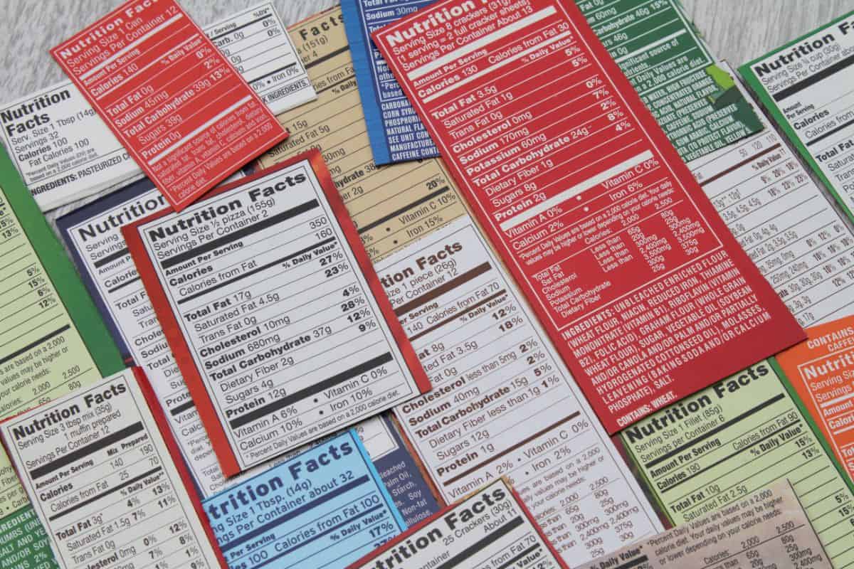 A large pile of various nutrition labels that show the nutrition facts and ingredients lists of store bought items.