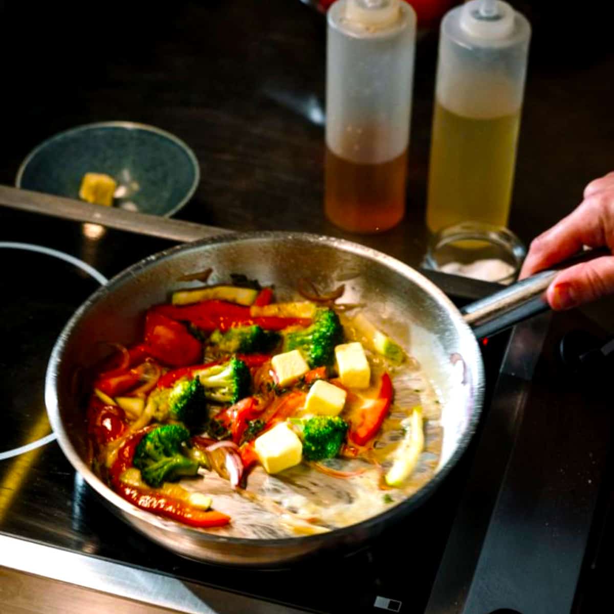 a pan of vegetables cooking with oil 