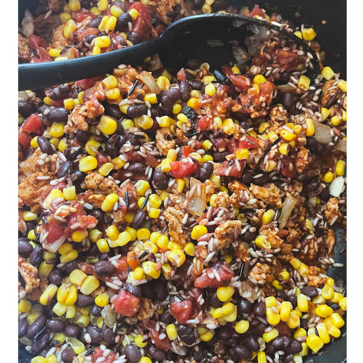 a skillet with rice beans corn tomato and ground turkey