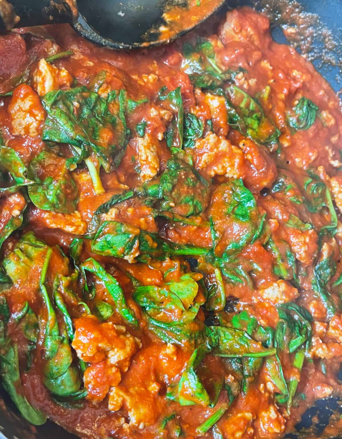sausage with spinach and marinara added in skillet