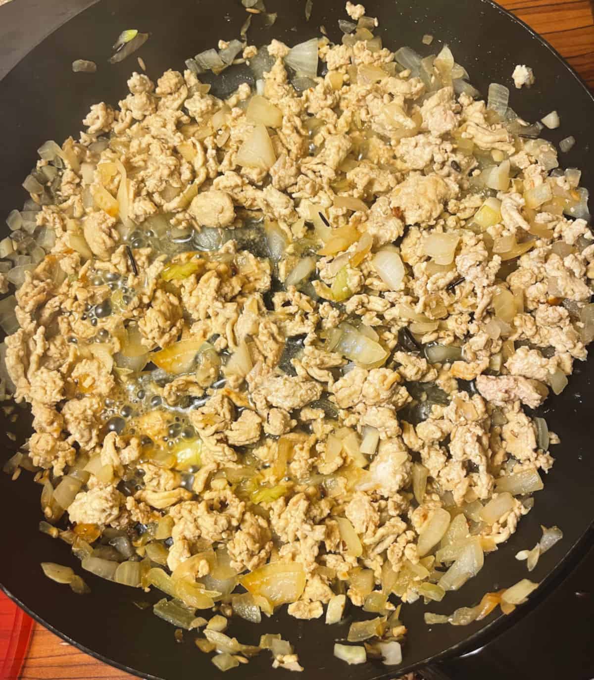 ground turkey cooking in a skillet with onions