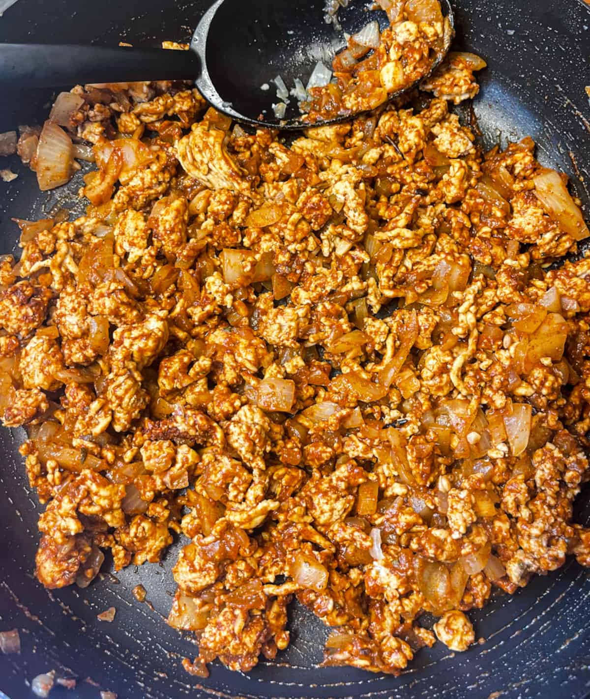 ground turkey in skillet with onion and taco seasoning mixed in