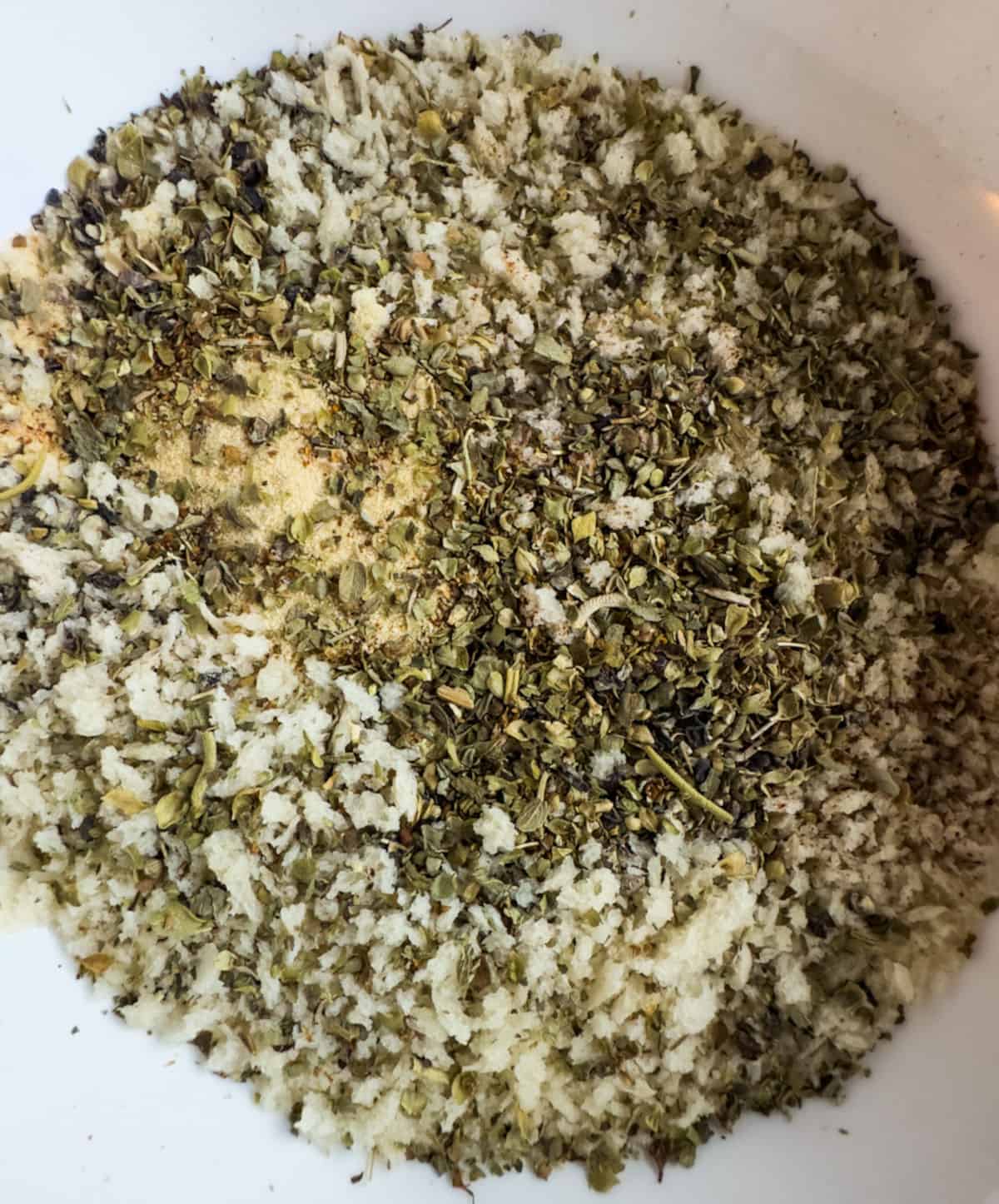 a white bowl with spices and panko bread crumbs mixed together for step one to cook yellowtail flounder