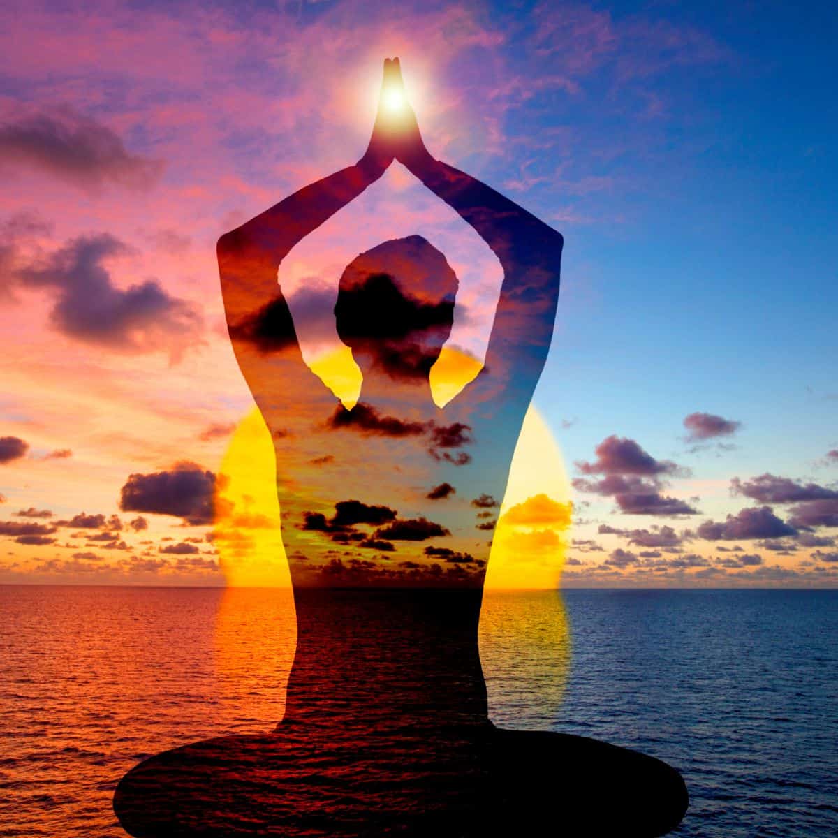 A beautiful sunset over the ocean with pink orange purple and blue colors and clouds in the sky with a silhouette of a cross-legged person holding a prayer pose with their hands above their head indicating mindfullyhealthyliving