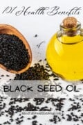 Pinterest optimized image of a rounded glass container filled with yellow black seed oil with a cork in it next to a wooden scoop of black seeds in it and scattered around it. Text overlay reads 101 Health Benefits of Black Seed Oil MindfullyHealthyLiving.com