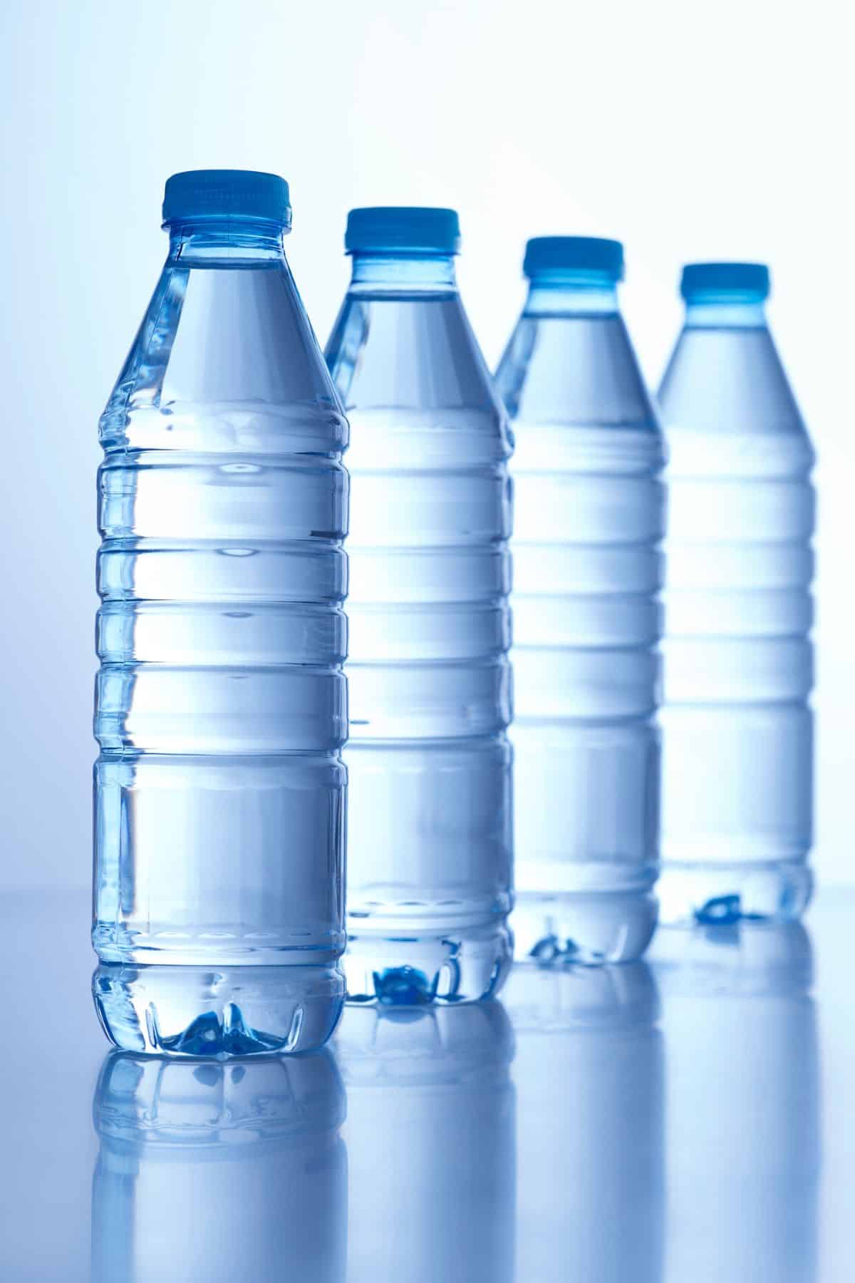 Four blue plastic water bottles lined up diagnally.