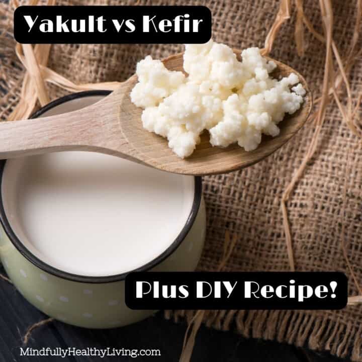A mig of kefir on a burlap cloth with a wooden spoon filled with kefir grains across the top of it. White writing with a black background says "Yakult vs kefir plus diy recipe mindfullyhealthyliving.com"