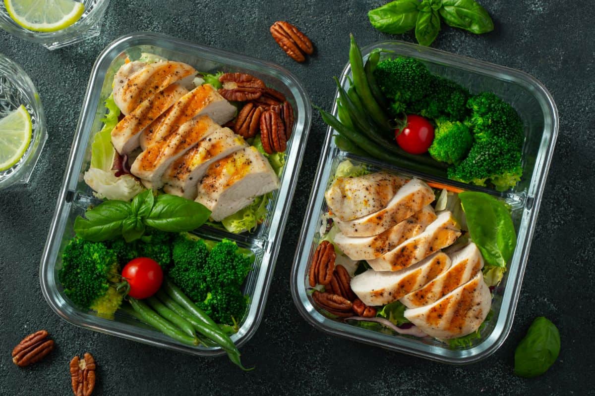 a photo of two rectangular meal prep containers with veggies and meat in each of them