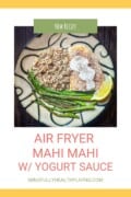 A white poster with yellow frame at the top and bottom only with a green box above a photo that says "new recipe" and below the photo in pink says "air fryer Mahi Mahi w/yogurt sauce" and in green below that says "mindfullyhealthyliving.com." The photo is a photo of a tan and black swirled decorative round plate with a Mahi Mahi fillet covered in lightly browned bread crumb and spice mixture and topped with spicy yogurt sauce that was seasoned with black pepper. Next to the fish is a lemon wedge, a pile of multi-colored quinoa, and a side of sautéed asparagus.