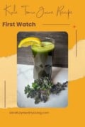 A bright orange and yellow background with a rounded photo in the middle of a green juice kale tonic with a lemon garnish and curly kale leaf. Text overlay says kale tonic juice recipe first watch mindfullyhealthyliving.com