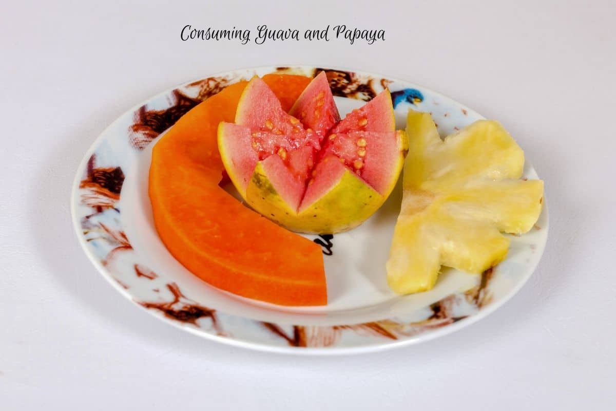 The text says "consuming guava and papaya" with a plate of cut papaya and cut guava in a star shape next to a slice of pineapple.
