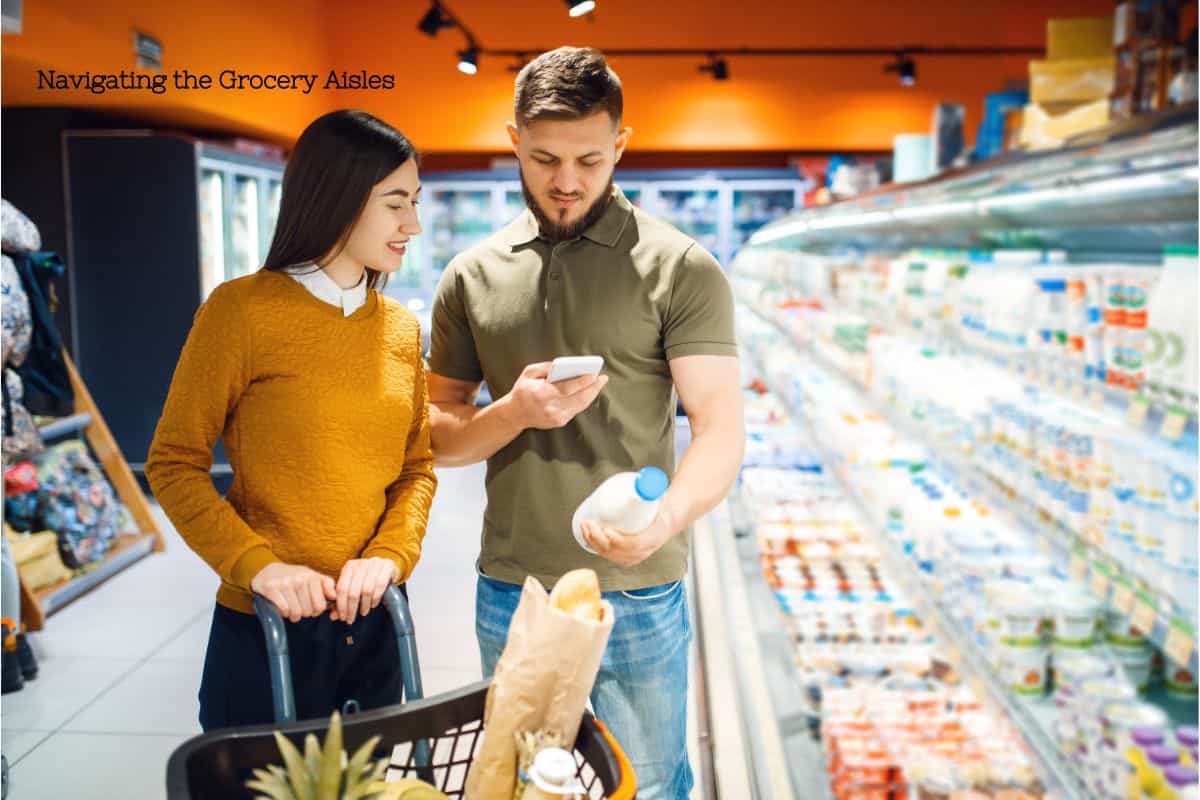 A man and a woman pushing a shopping cart filled with groceries. The man is holding a jar of milk and a cell phone, indicating they are reading and researching the ingredients. Text overlay says navigating the grocery aisles