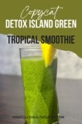 A torn photo look with a photo of a tall glass of detox island green smoothie with bright green colors and tiny dark green speckles. The glass is garnished with a slim slice of pineapple. Text says copycat detox island green tropical smoothie mindfullyhealthyliving.com