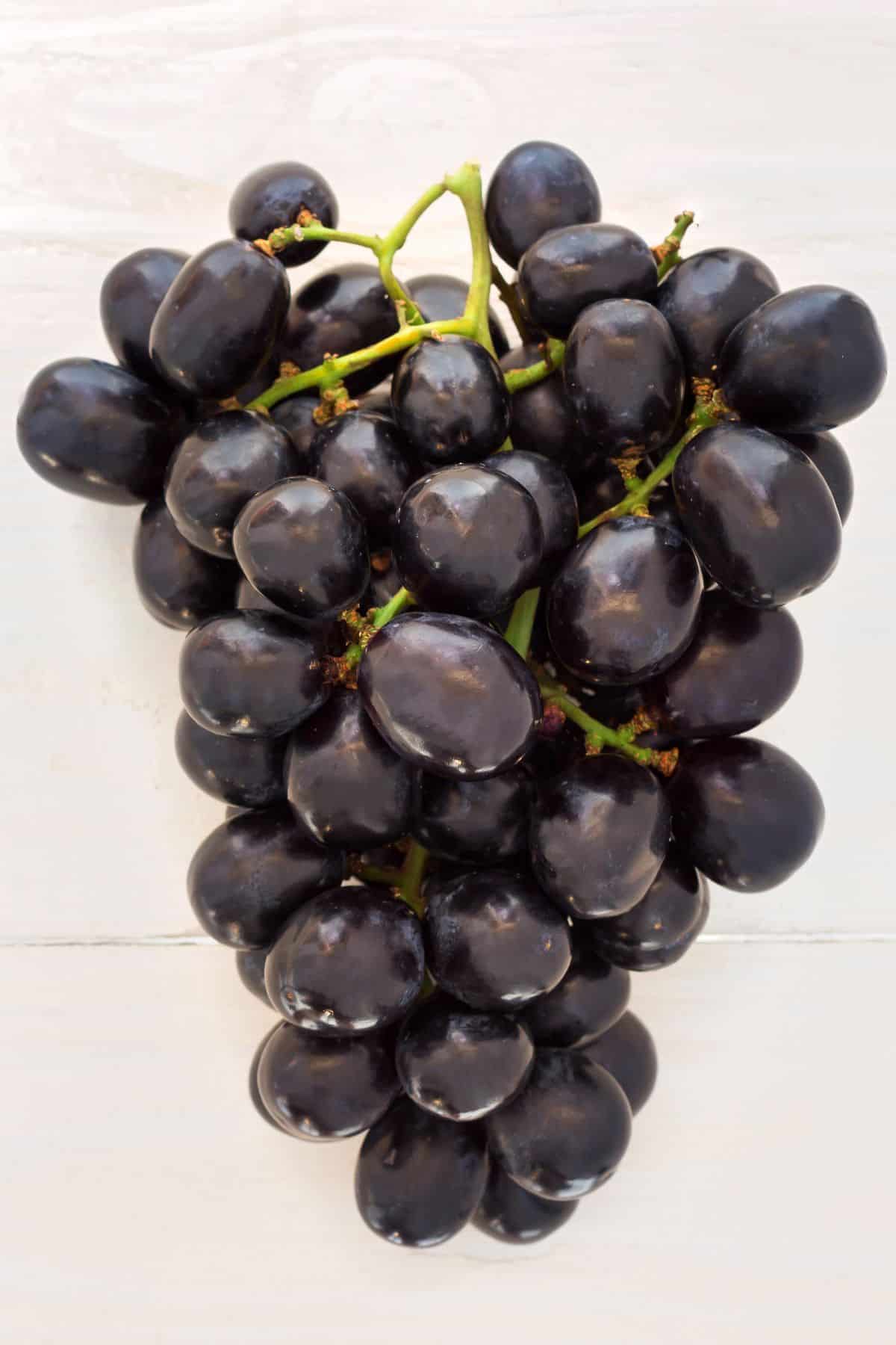 a bunch of deep dark purple grapes.