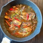 The completed Southern Cajun Smothered Chicken, richly coated in gravy with herbs, served hot straight from the skillet.