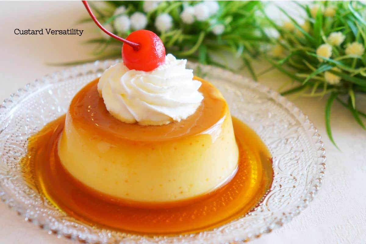 Golden caramel custard on a glass plate garnished with whipped cream and a cherry, showcasing the dessert's versatility, with soft-focus greenery in the background.