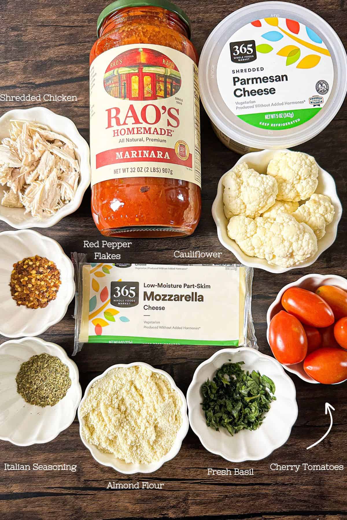 All the wholesome ingredients laid out for Keto Parmesan Chicken Casserole, including marinara sauce, cheeses, cauliflower, and spices