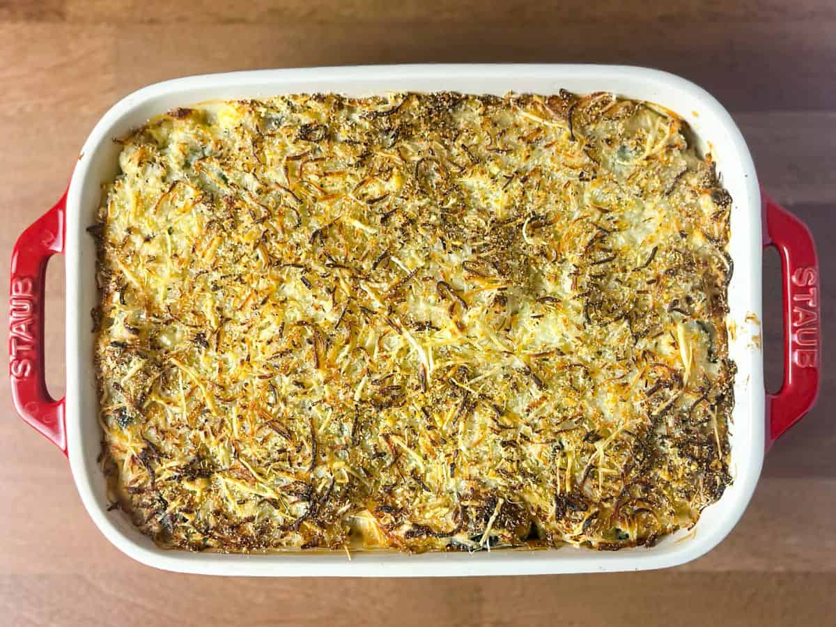 Freshly baked Keto Spinach Artichoke Chicken Casserole with a crispy golden-brown cheese topping.