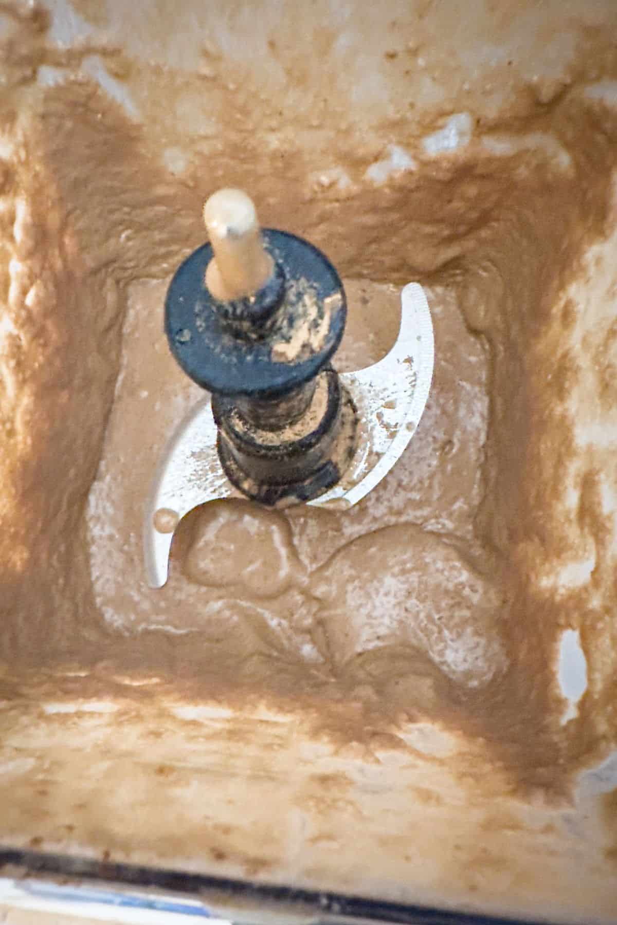 Overhead view of a high-speed blender filled with ingredients for a Peanut Butter Cup smoothie, including ice, showcasing the blending process for a creamy result.