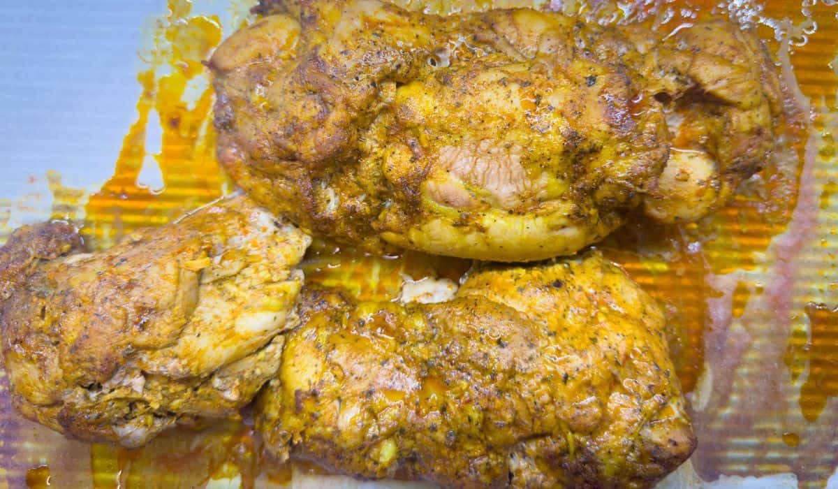 Cooked Trader Joe's Chicken Shawarma thighs glistening with marinade, resting on a baking sheet with caramelized edges.