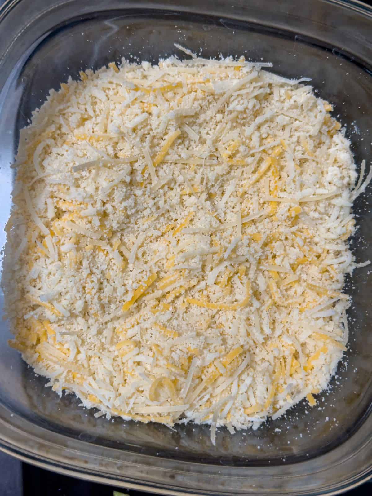 Keto casserole topping of almond flour and shredded cheese mixed in a bowl, ready to be spread over the dish.