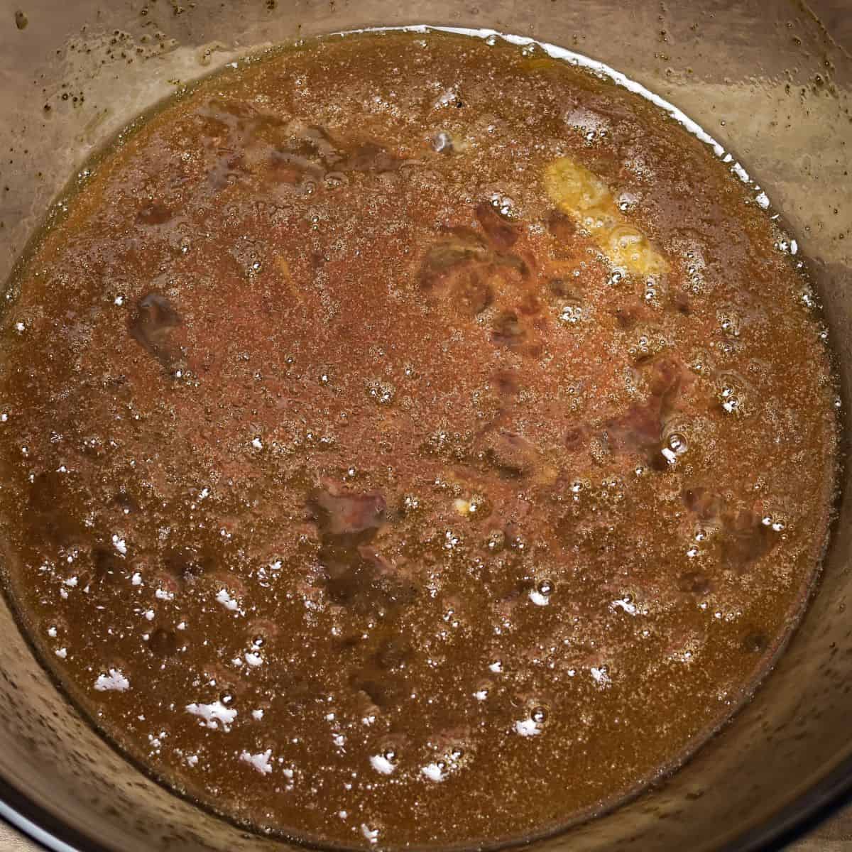 Melted coconut oil, maple syrup, and eggs in a bowl, beginning to be mixed for brownie batter.