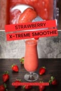 A promotional image featuring the strawberry smoothie in a glass, similar to the first image, with the text "STRAWBERRY X-TREME SMOOTHIE" in bold red font across it and the website "MINDFULLYHEALTHYLIVING.COM" at the bottom. The background includes scattered strawberries on a wooden surface with a gray backdrop.