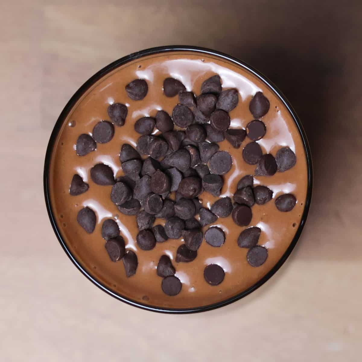 A chocolate peanut butter smoothie with creamy texture is garnished with chocolate chips.