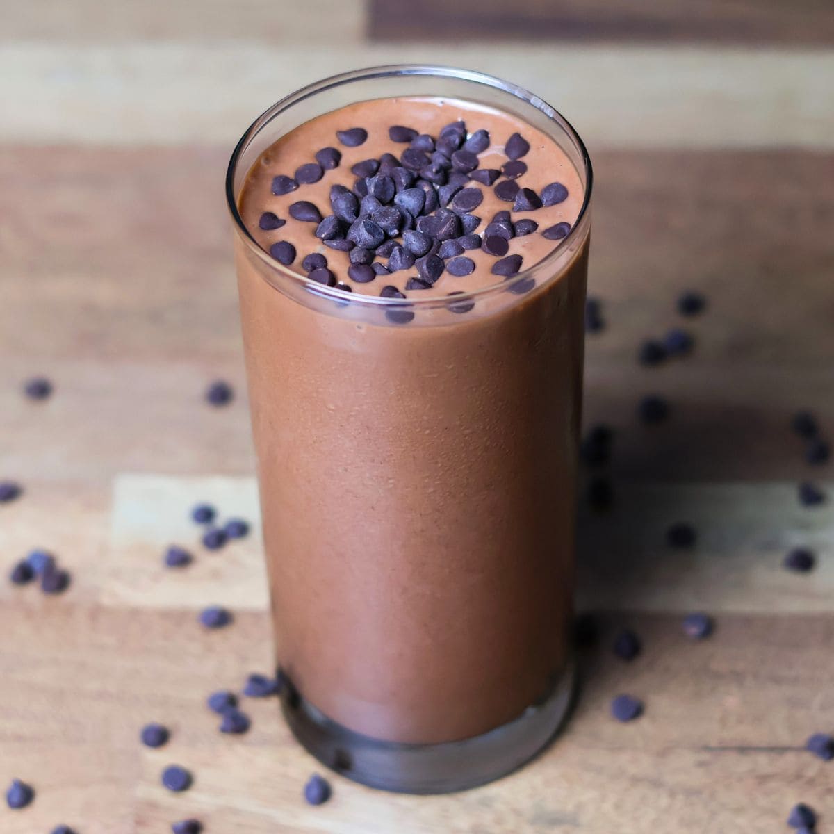 A chocolate peanut butter smoothie with creamy texture is garnished with chocolate chips.	