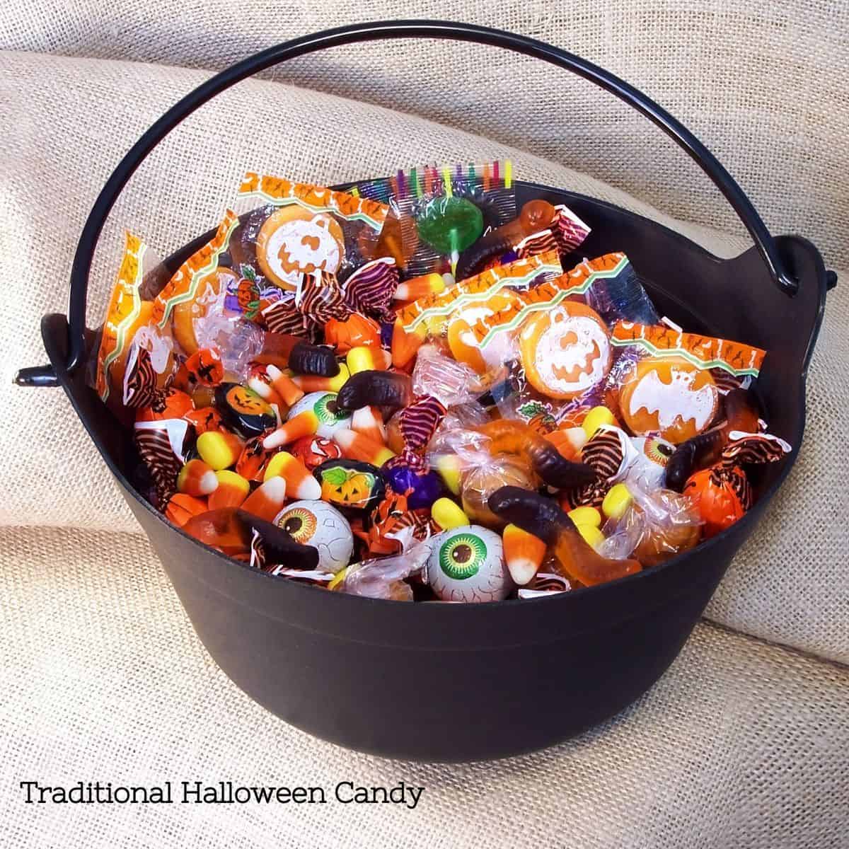A black bucket of traditional Halloween candy.