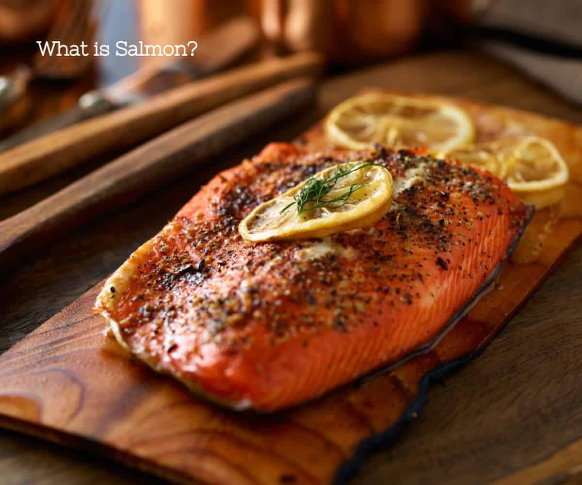 A decadent photo of a large salmon fillet with plenty of seasonings on a wood plank.