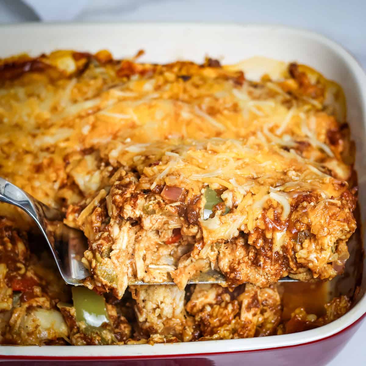 A slice of chicken enchilada casserole being served.