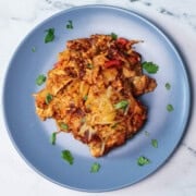 A serving of keto sour cream enchilada casserole plated and garnished with cilantro.