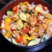 A Hawaiian BBQ Chicken Bowl garnished with red pepper flakes.