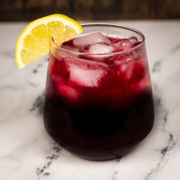 A finished glass of adrenal cocktail with a lemon garnish.