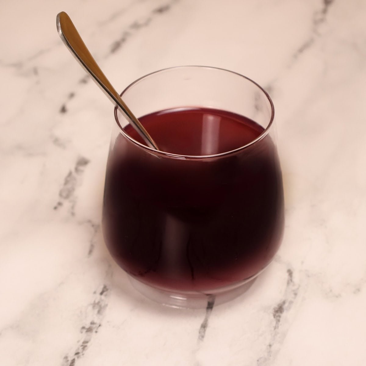 A spoon in a glass of adrenal cocktail ready to stir.