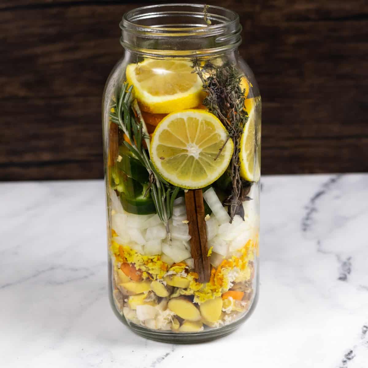 Ingredients for fire cider layered in a jar ready for vinegar.